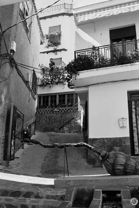 A black-and-white photo of La Escoba Mágica (Magic Broom) in the narrow streets.