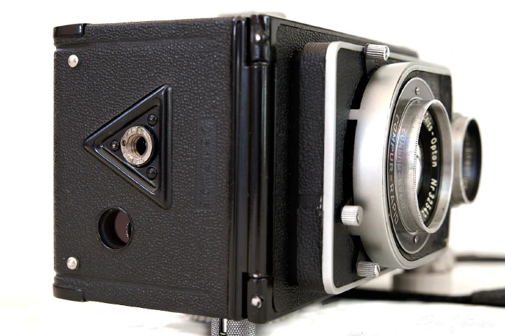 The underside of the camera with the red glass film viewing window next to the tripod socket.