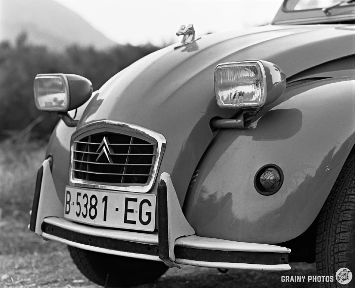 A black-and-white photo of the front of a Citroen 2CV car.