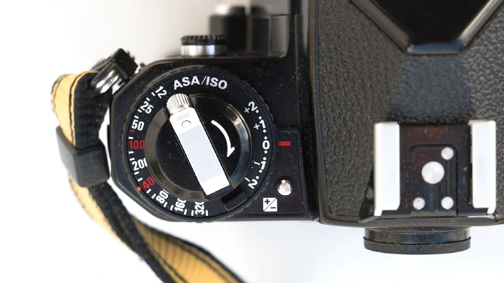 A photo of the LHS of the Nikon FE2 top-plate with film ISO dial, exposure compensation and film rewind crank. The flash hot-shoe is on the prism housing.