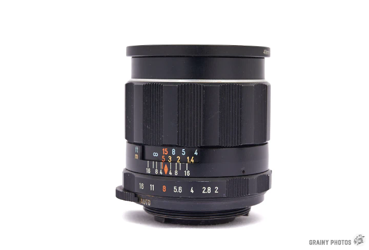 A photo of the Super-Takumar 35mm f2 lens standing vertically with the front lens uppermost.