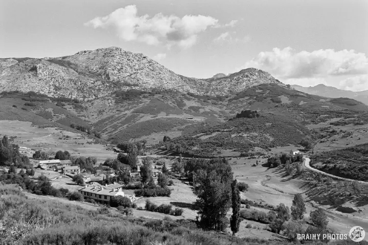 A black-and-white film photo of Barrio Castro nestling in a valley