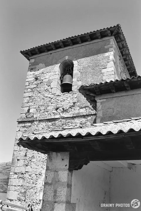 A black-and-white film photo of the bell tower of Iglesia de San Justo y Pastor