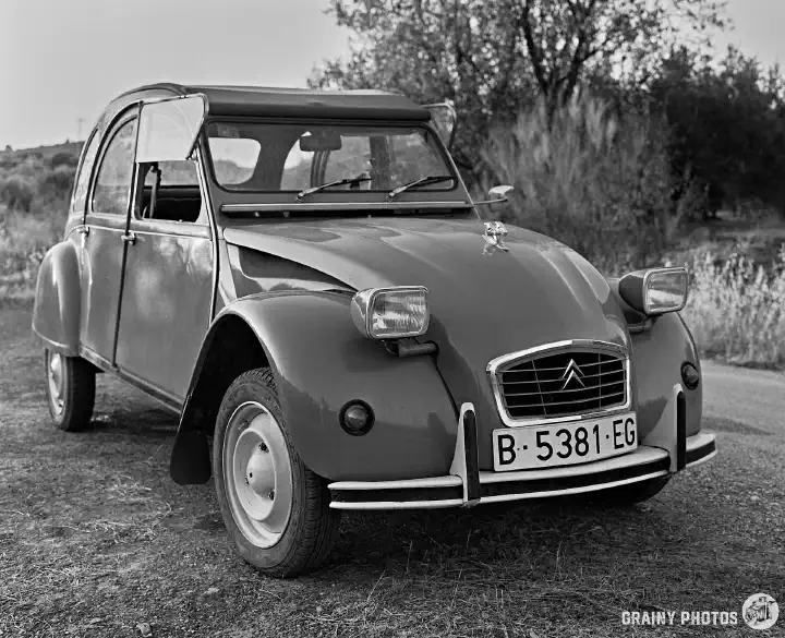 A black-and-white film photo - general view of a Citroën 2 CV from the front