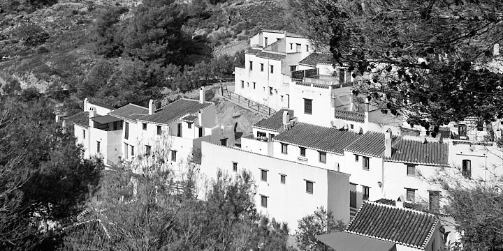 A black-and-white photo of El Acebuchal nestling on the side of the valley.