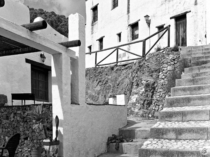 A black-and-white film photo of steps between the streets in the village