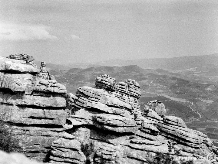 A black-and-white film photograph of Karst limestone rock formations in El Torcal