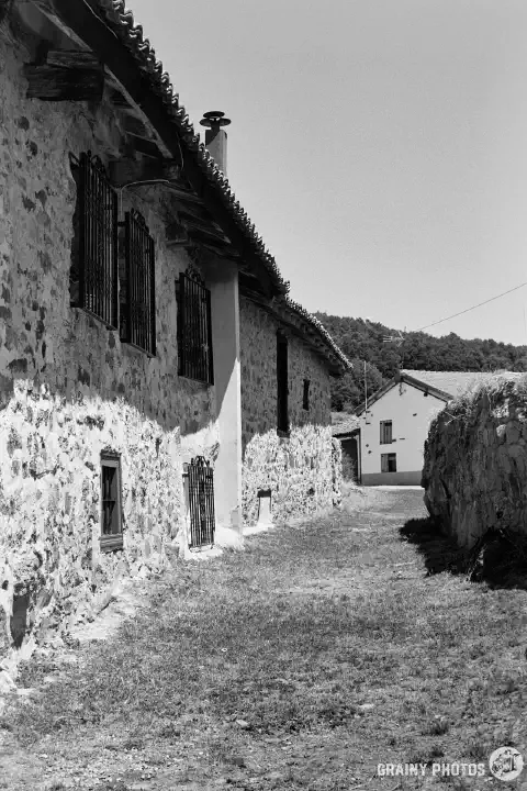 A black-and-white photo of a row of terraced stone houses in Estalaya