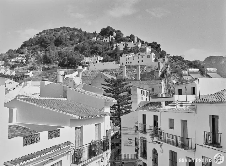 A black-and-white photo of the white houses of Frigiliana on a hillside.