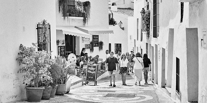 A black-and-white film photo of a street in Frigiliana.