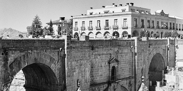 A black-and-white film photo of the Puente Nuevo (New Bridge) in Ronda.