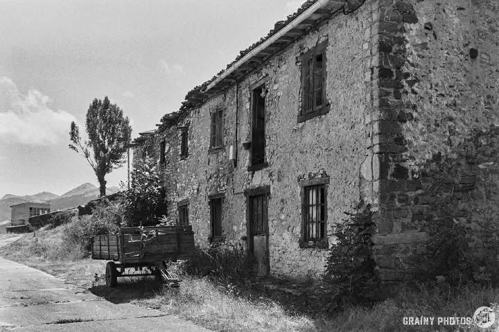 A black-and-white film photo of the abandoned terraced houses viewed from the other end