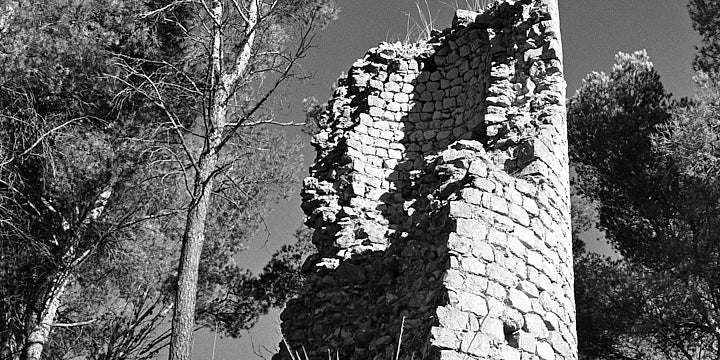 A black-and-white film photo of the ruins of the Torre de la Harina watch tower