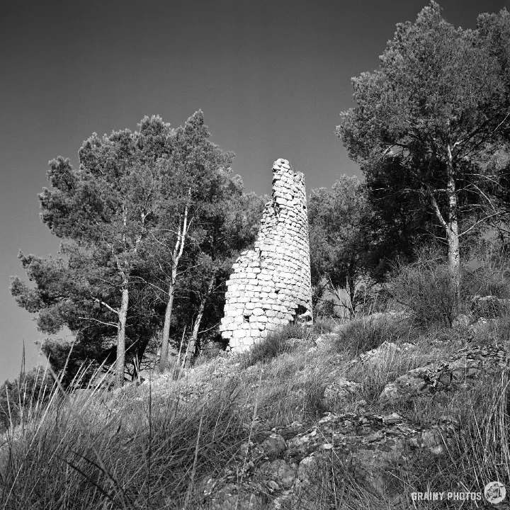 A black-and-white photo of the ruins of the Torre de la Harina watch tower.