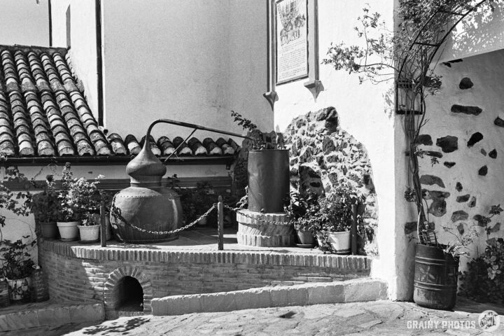 A black-and-white photo of an old still in the town square behind the church.